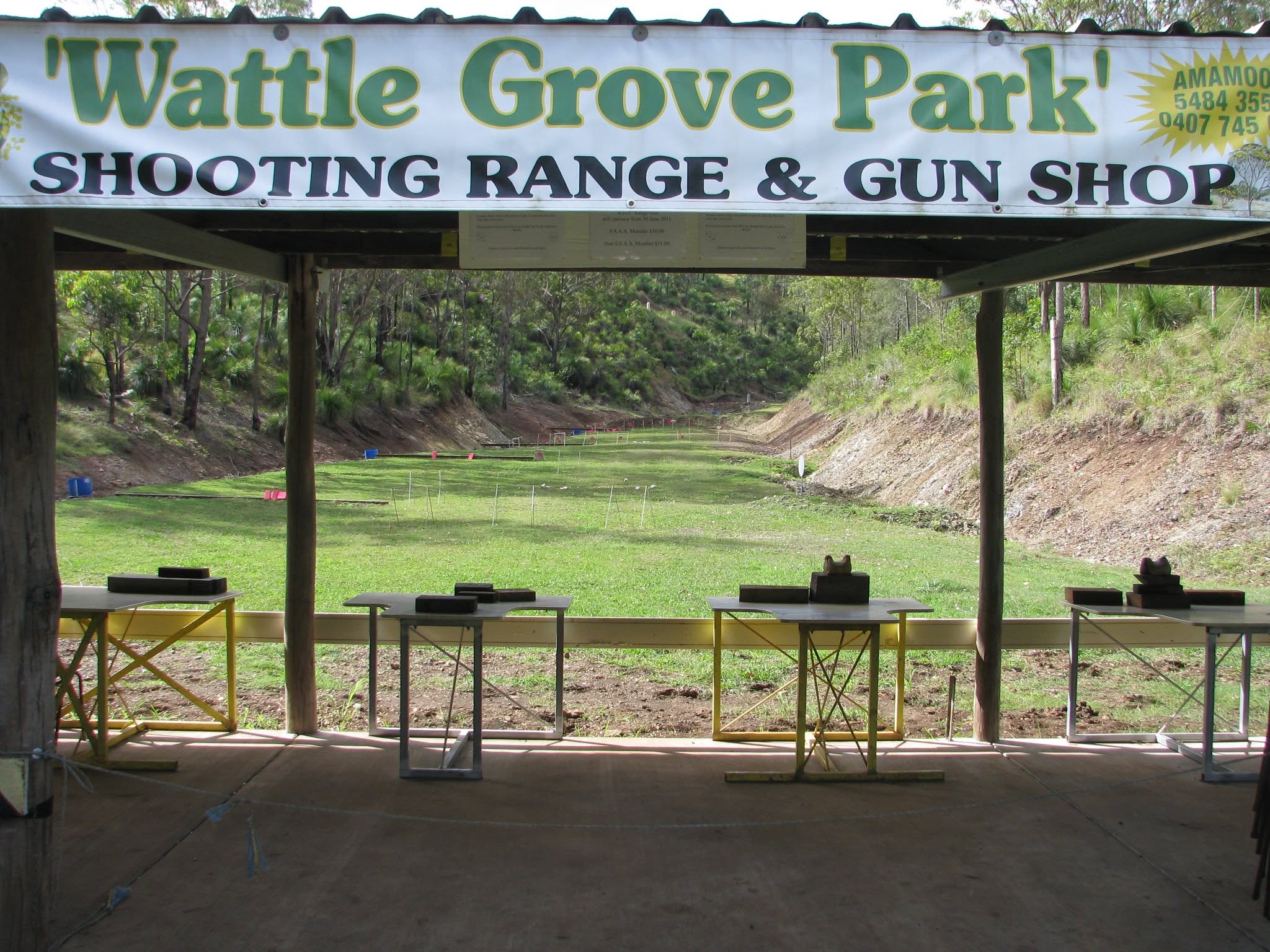 Covered firing line at Wattle Grove Park Shooting Range with the range banner and benches looking downrange