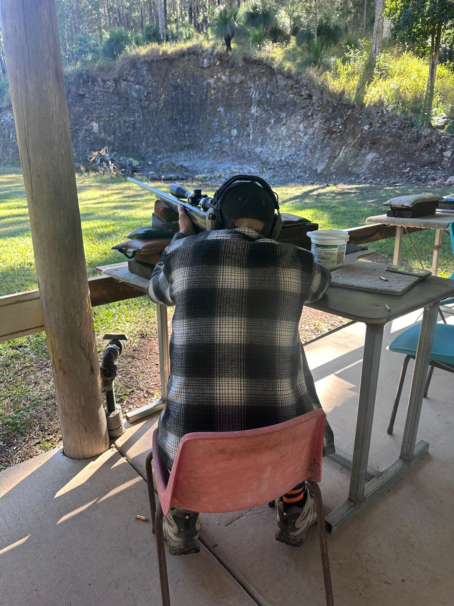 Shooter lining up a shot from a covered bench at Wattle Grove Park